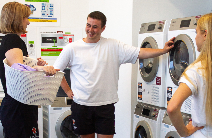 Students using electric washing machines in Colombo House laundry